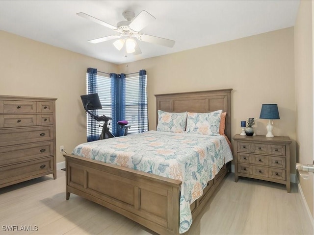 bedroom with light wood finished floors, baseboards, and a ceiling fan