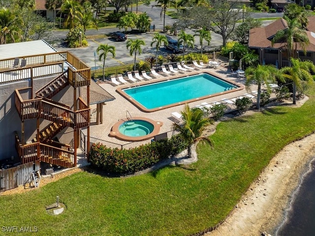 community pool with a community hot tub, stairway, a patio area, and fence