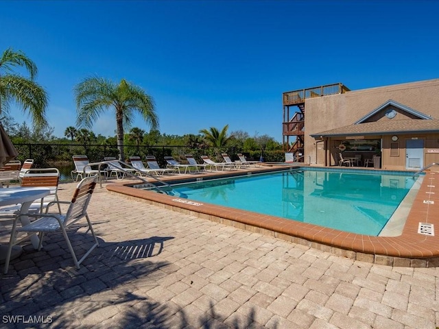 community pool featuring a patio and fence