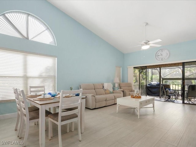 living area featuring high vaulted ceiling, light wood finished floors, and a ceiling fan