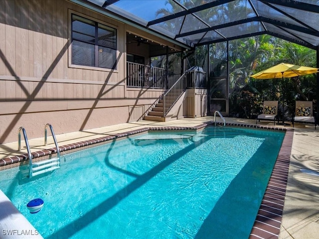 pool featuring a lanai, a patio area, and stairway