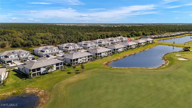 drone / aerial view featuring golf course view, a residential view, a wooded view, and a water view