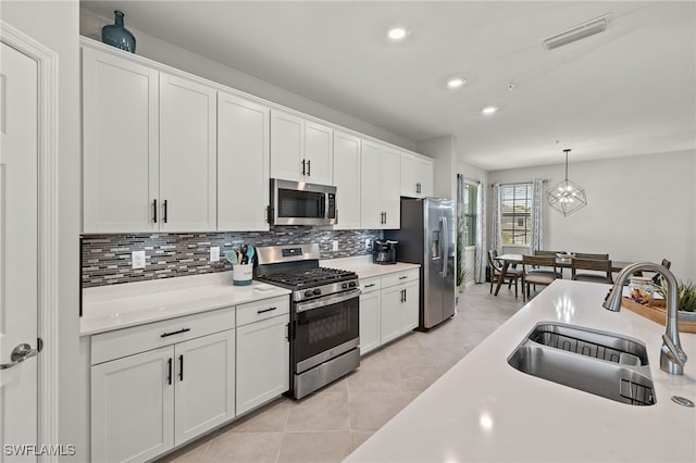 kitchen featuring visible vents, light tile patterned flooring, a sink, decorative backsplash, and appliances with stainless steel finishes