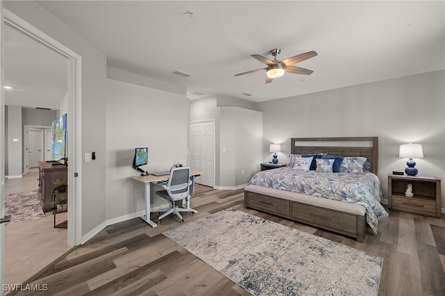 bedroom featuring visible vents, baseboards, a closet, and wood finished floors