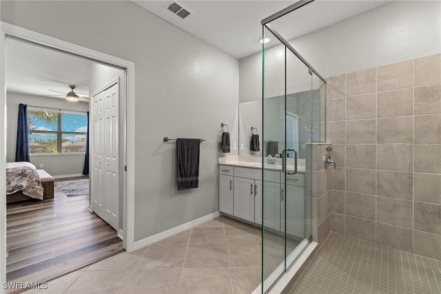 full bath featuring tile patterned flooring, visible vents, ceiling fan, a stall shower, and vanity