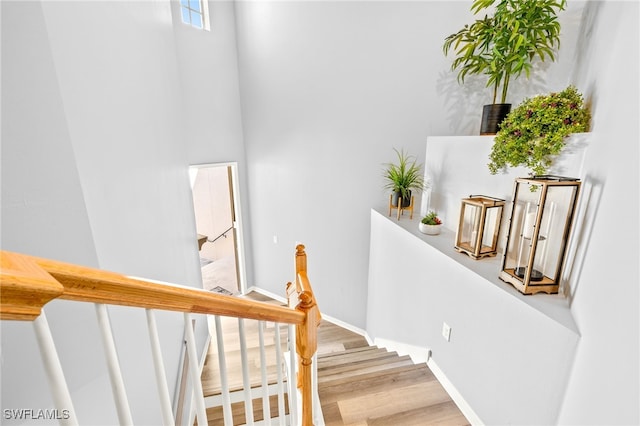 staircase featuring baseboards and wood finished floors