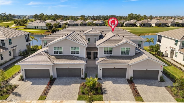 view of front of home with a residential view, decorative driveway, and a water view