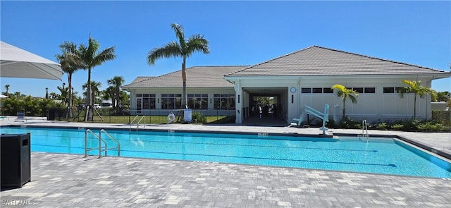 community pool with a patio and fence