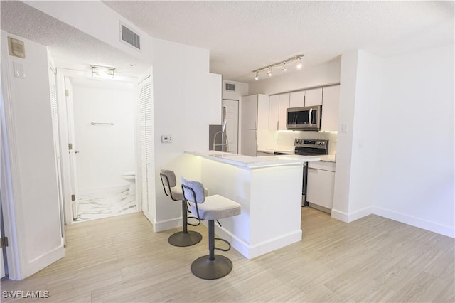 kitchen with visible vents, appliances with stainless steel finishes, light countertops, and a textured ceiling