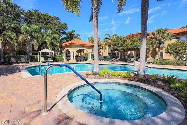 community pool featuring a patio area, a hot tub, and a gazebo