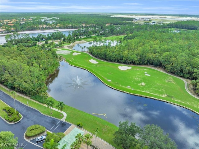 birds eye view of property with a wooded view, golf course view, and a water view