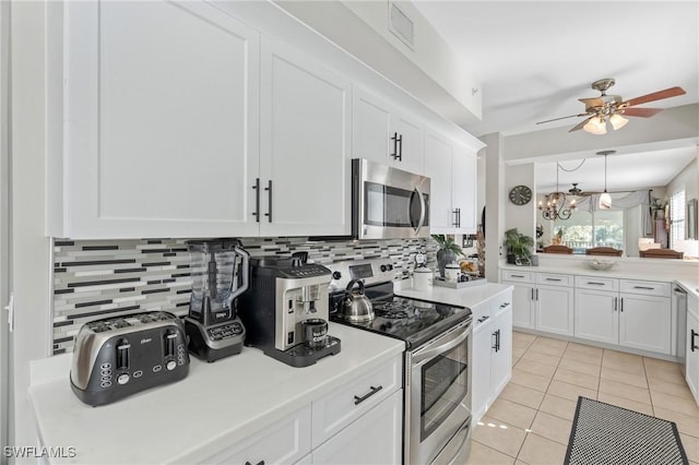 kitchen with light tile patterned floors, light countertops, white cabinets, appliances with stainless steel finishes, and backsplash