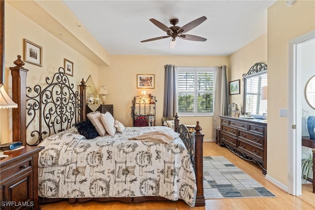 bedroom with baseboards, a ceiling fan, and light wood finished floors