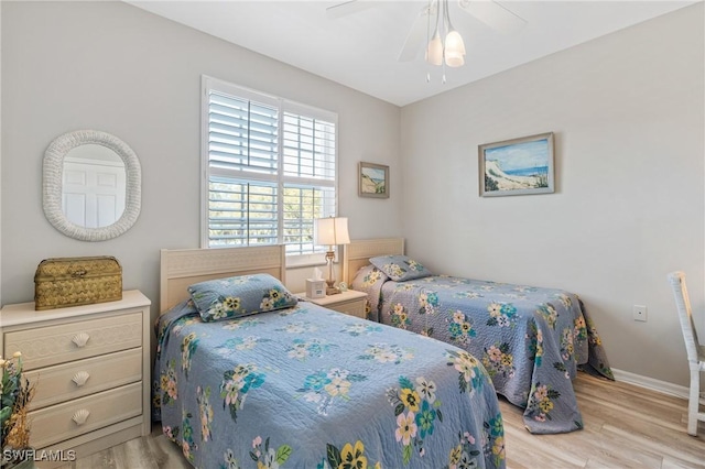 bedroom with ceiling fan, baseboards, and wood finished floors