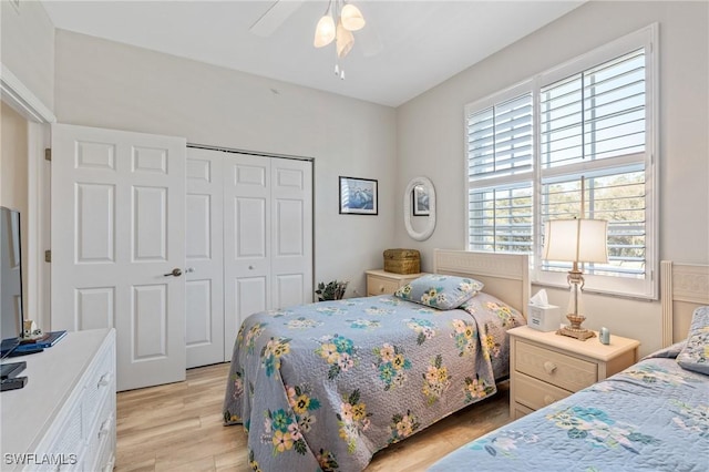 bedroom featuring a closet, light wood-style flooring, and a ceiling fan