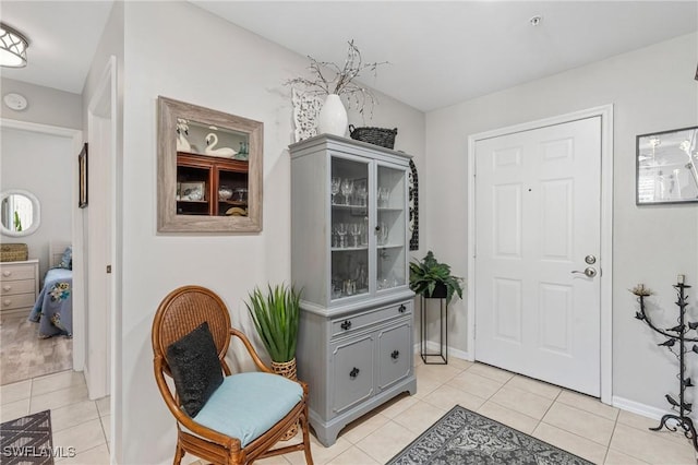 entryway featuring light tile patterned floors and baseboards