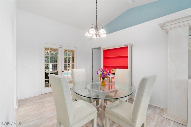 dining room with lofted ceiling, wood finished floors, baseboards, french doors, and an inviting chandelier