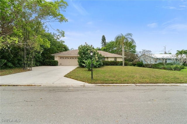 view of front of house with an attached garage, concrete driveway, and a front yard