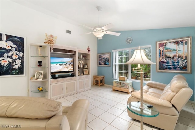 living room featuring ceiling fan, visible vents, vaulted ceiling, and light tile patterned flooring