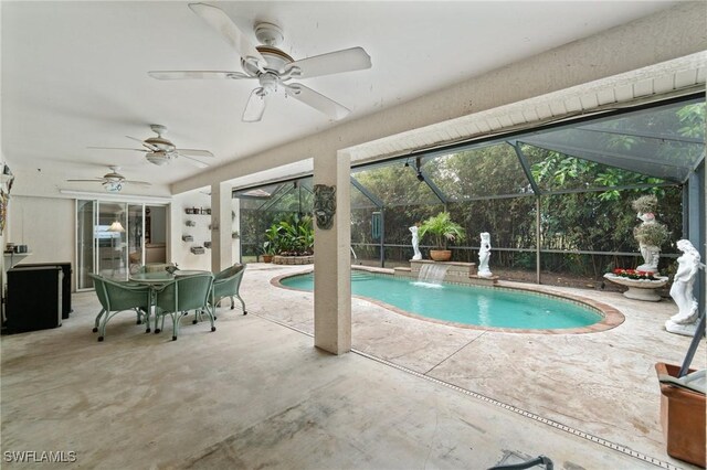 outdoor pool with a patio area, glass enclosure, and a ceiling fan