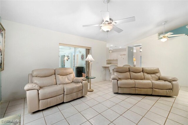 living room featuring lofted ceiling, light tile patterned floors, and ceiling fan