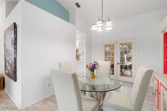 dining space featuring french doors, visible vents, an inviting chandelier, light wood-type flooring, and baseboards