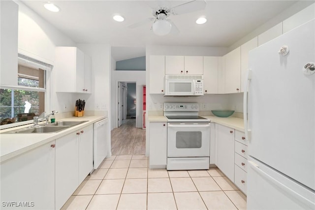 kitchen with white appliances, light countertops, white cabinetry, a sink, and light tile patterned flooring