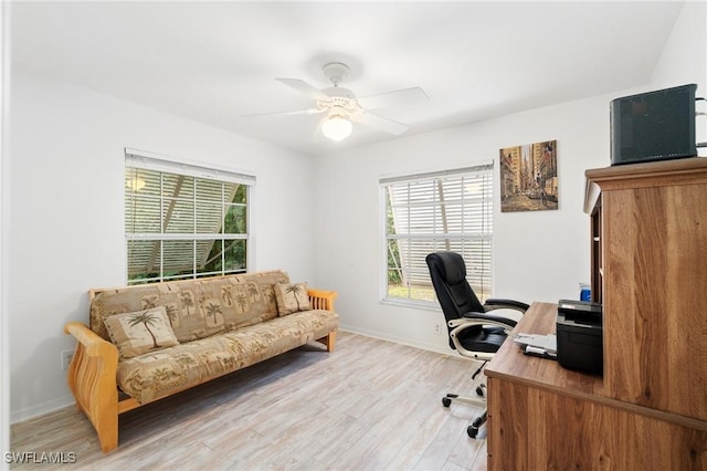 office space featuring a ceiling fan, light wood-style flooring, and baseboards