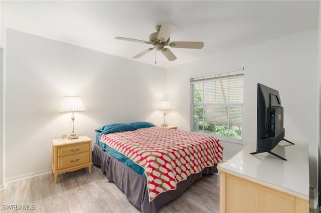 bedroom featuring light wood-style flooring, baseboards, and ceiling fan