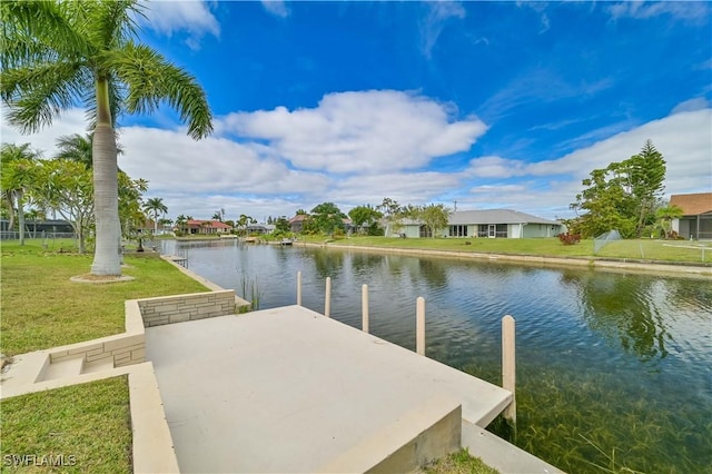 dock area with a water view and a lawn