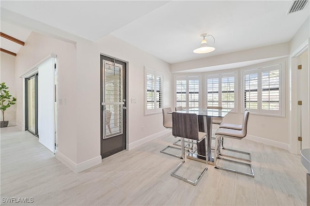 dining room featuring light wood-type flooring, baseboards, and visible vents