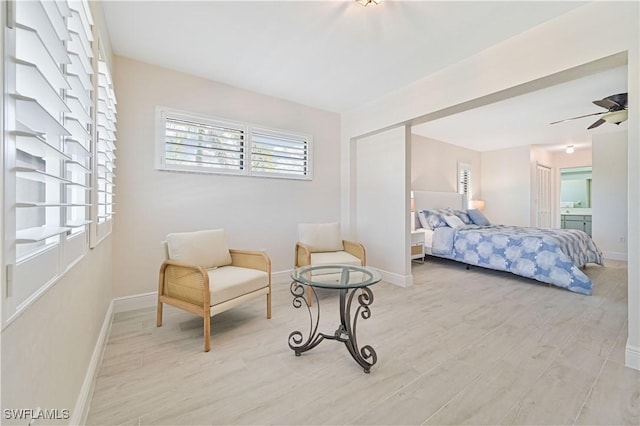 bedroom featuring light wood-type flooring, ensuite bath, and baseboards