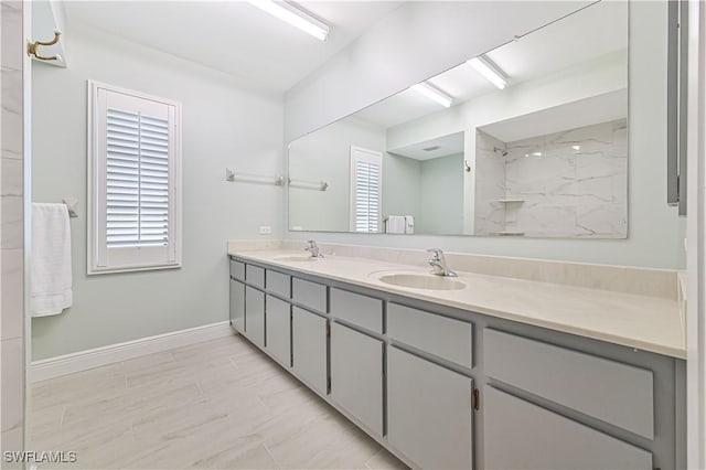 bathroom with double vanity, baseboards, and a sink