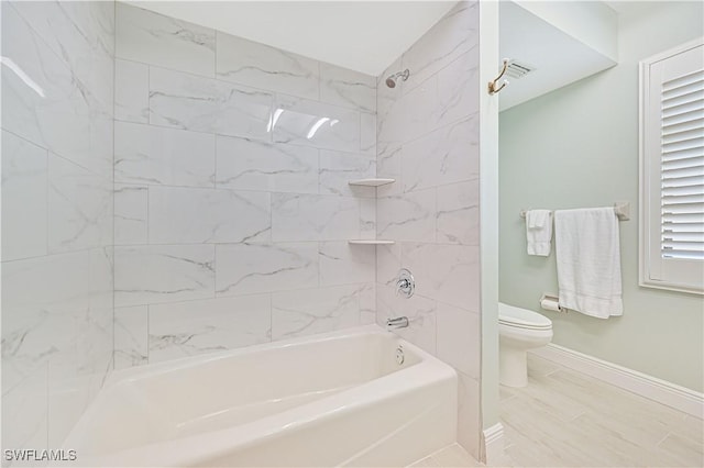 full bathroom with baseboards, toilet, and shower / bathtub combination