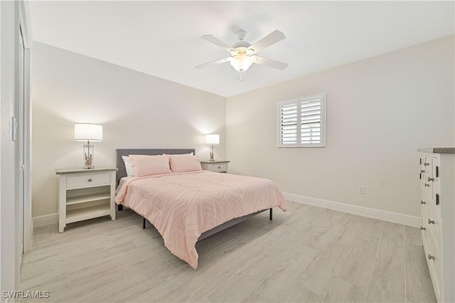 bedroom featuring light wood-style floors, ceiling fan, and baseboards