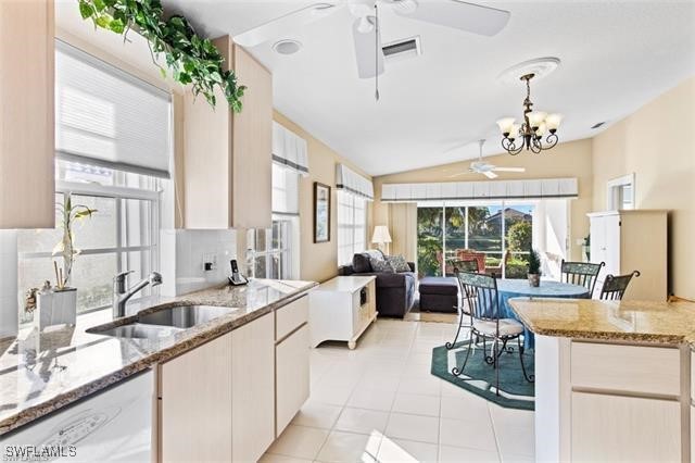 kitchen featuring a healthy amount of sunlight, a sink, dishwasher, and ceiling fan with notable chandelier