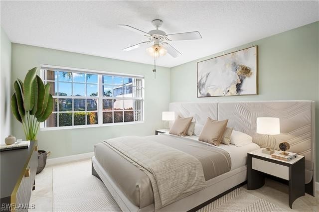 bedroom with a textured ceiling, a ceiling fan, and baseboards