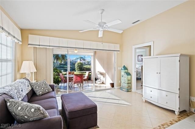 living area with lofted ceiling, ceiling fan, visible vents, and light tile patterned flooring