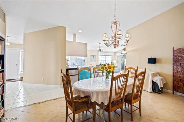 dining room with baseboards, a chandelier, and light tile patterned flooring