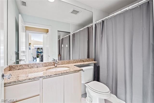 bathroom featuring toilet, visible vents, and vanity