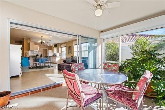 dining space featuring ceiling fan with notable chandelier and tile patterned flooring