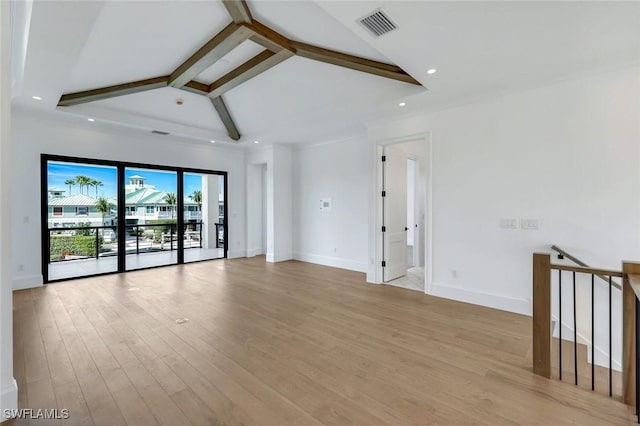 spare room featuring beam ceiling, visible vents, light wood-style flooring, and baseboards