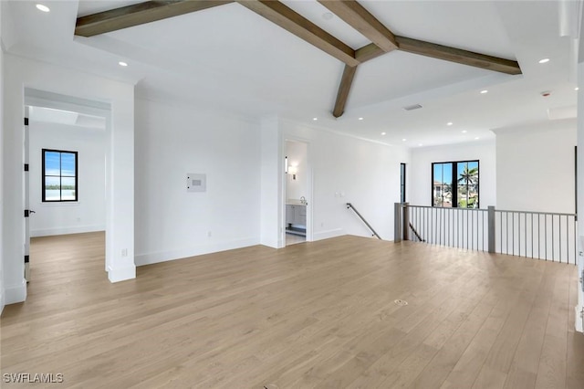 spare room featuring baseboards, lofted ceiling with beams, recessed lighting, and light wood-style floors