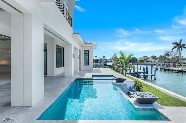 outdoor pool with a water view, a patio area, a hot tub, and a dock