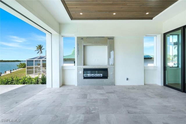 view of patio / terrace featuring a lanai and a water view