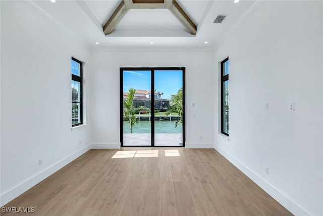 unfurnished room featuring light wood-style flooring, beamed ceiling, visible vents, and baseboards