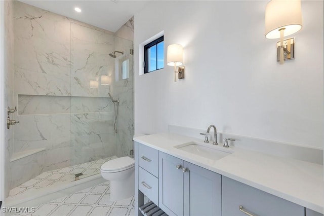 bathroom featuring toilet, a marble finish shower, and vanity