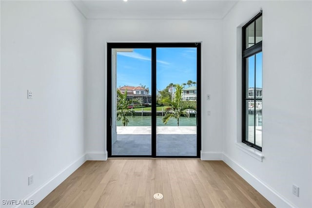 doorway to outside with light wood-style floors, plenty of natural light, and baseboards