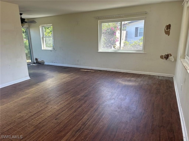 spare room with dark wood-style flooring and baseboards