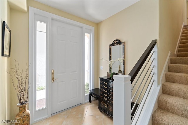 entrance foyer with light tile patterned floors and stairs